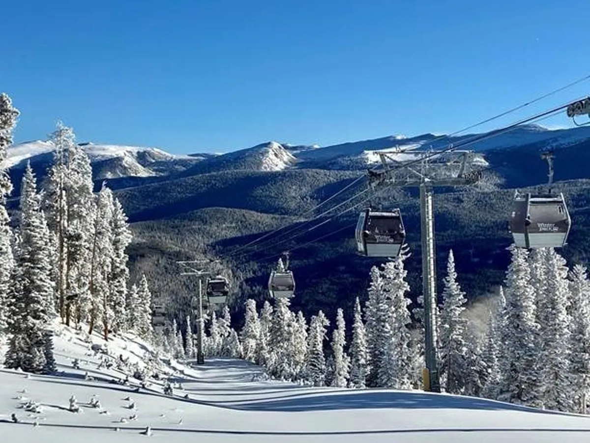 A wide exterior view of ski lift gondolas gliding above snow-covered trees, with distant mountains creating a breathtaking backdrop. The snowy landscape evokes the outdoor activities available just minutes from the home.