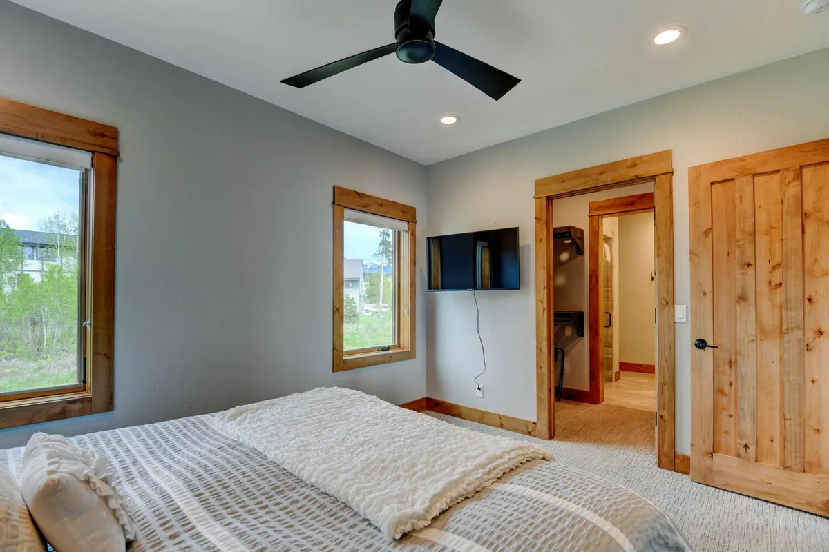 A peaceful bedroom scene with a bed covered in textured linens, large windows letting in natural light, and wooden accents that evoke a rustic, tranquil vibe. The overall atmosphere is quiet and restful, ideal for deep sleep and rejuvenation.